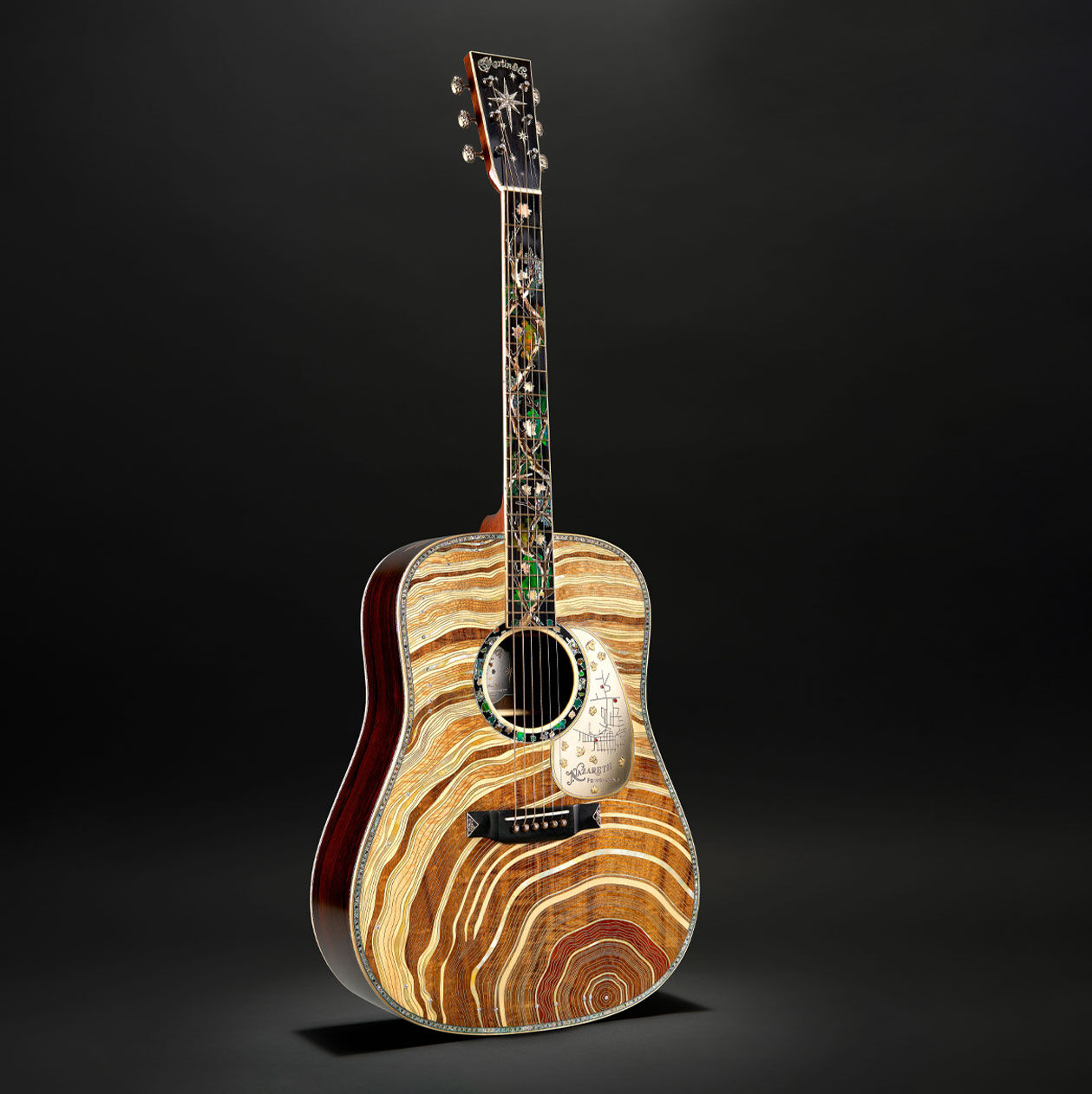 The Martin D-3-Millionth acoustic guitar featuring tree rings on the front. It is standing against a black background.