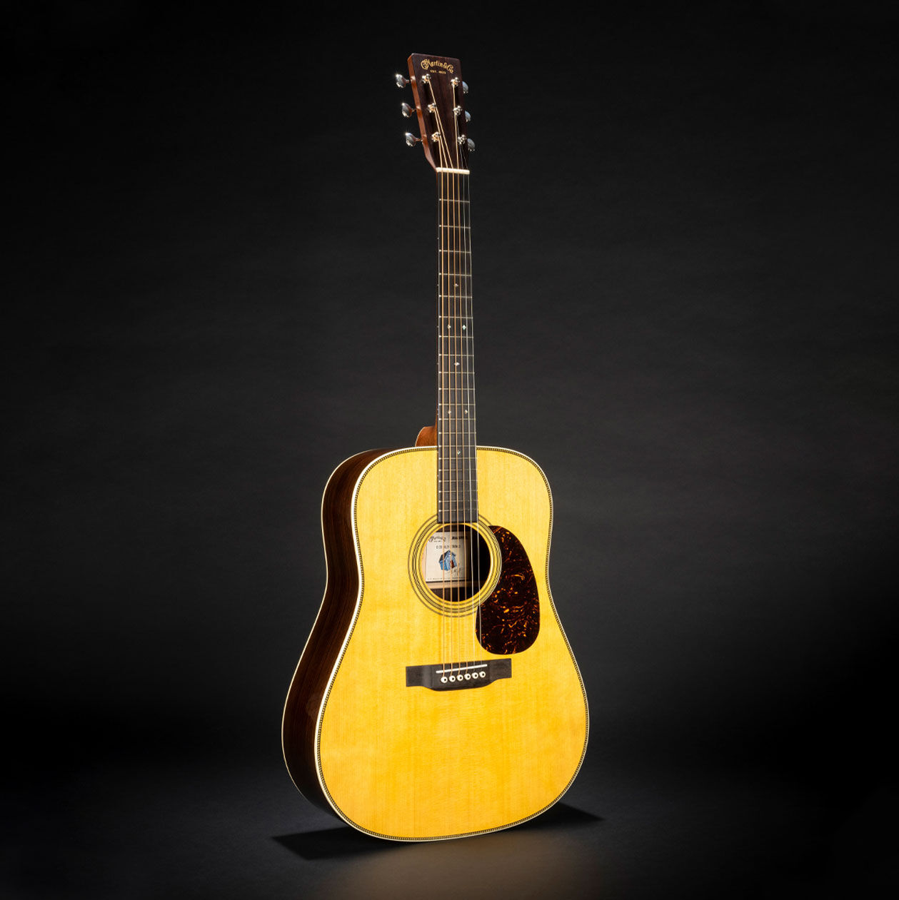 Photo of the D-28 Billy Strings acoustic guitar on a black background