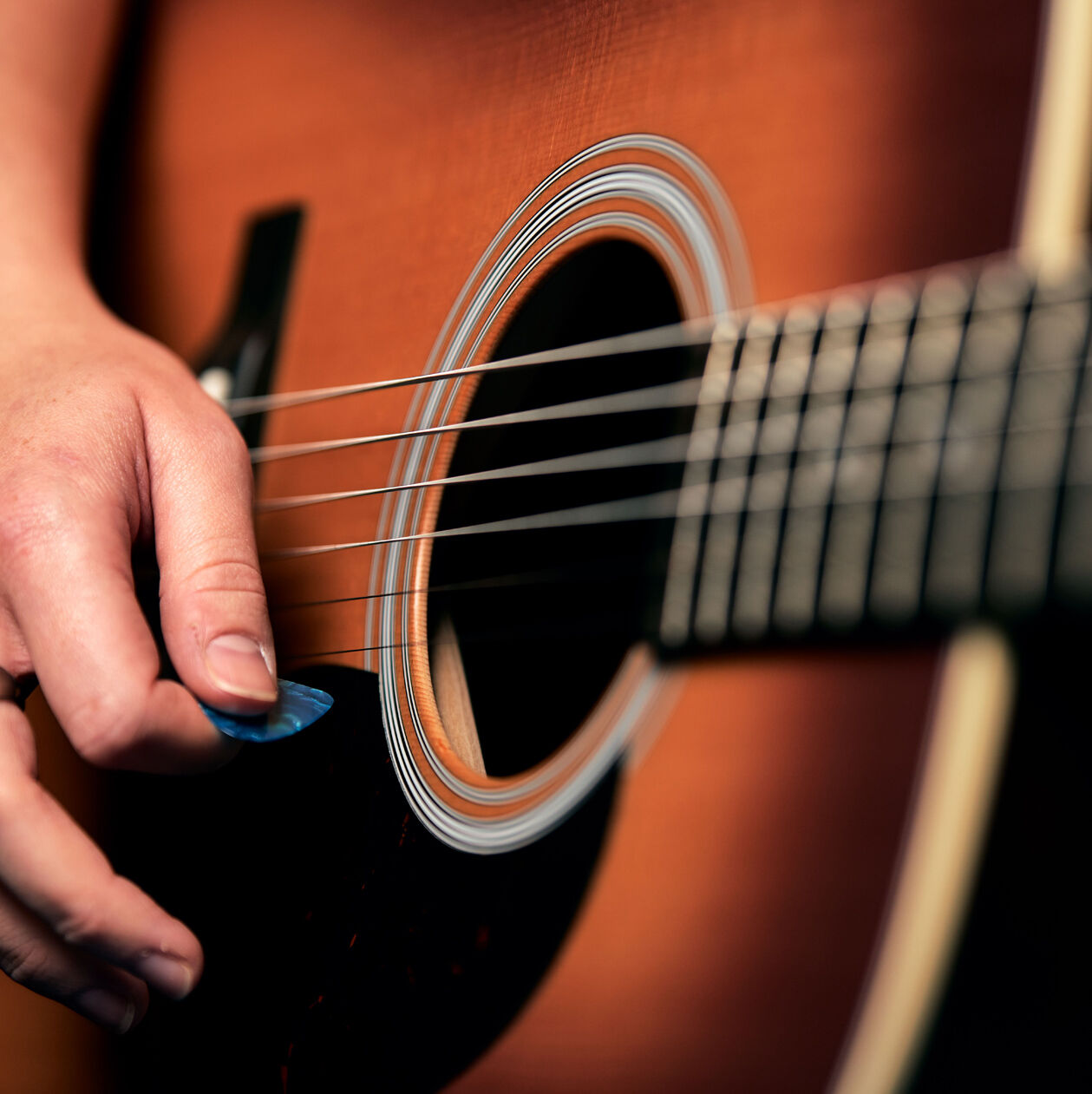 Closeup of an acoustic guitar sound hole and strings