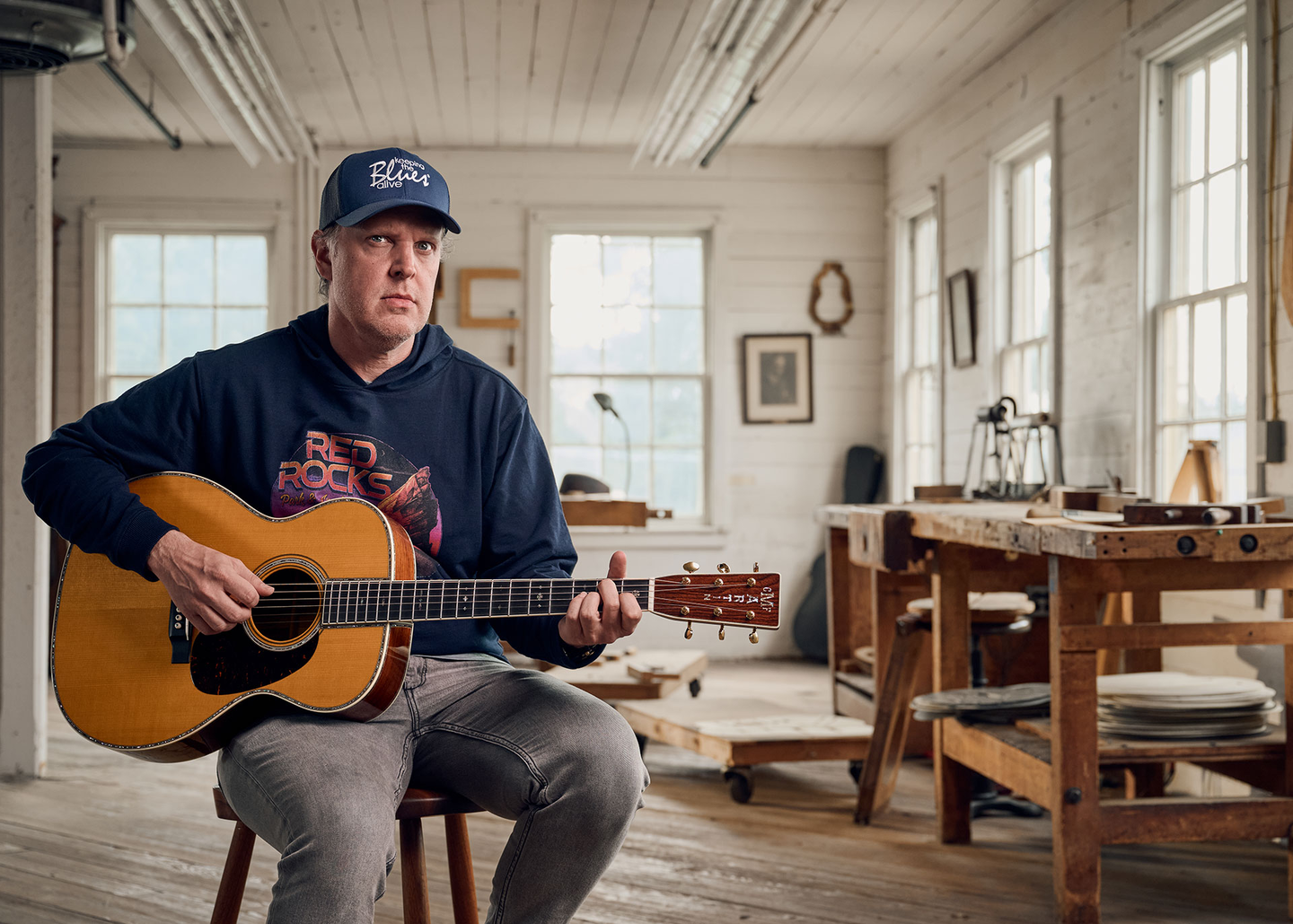 Joe Bonamassa sitting down playing an acoustic guitar