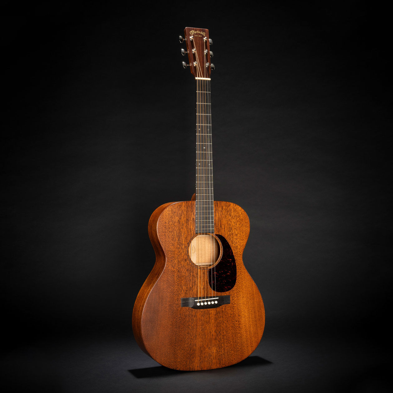 The 000-17 acoustic guitar on a black background