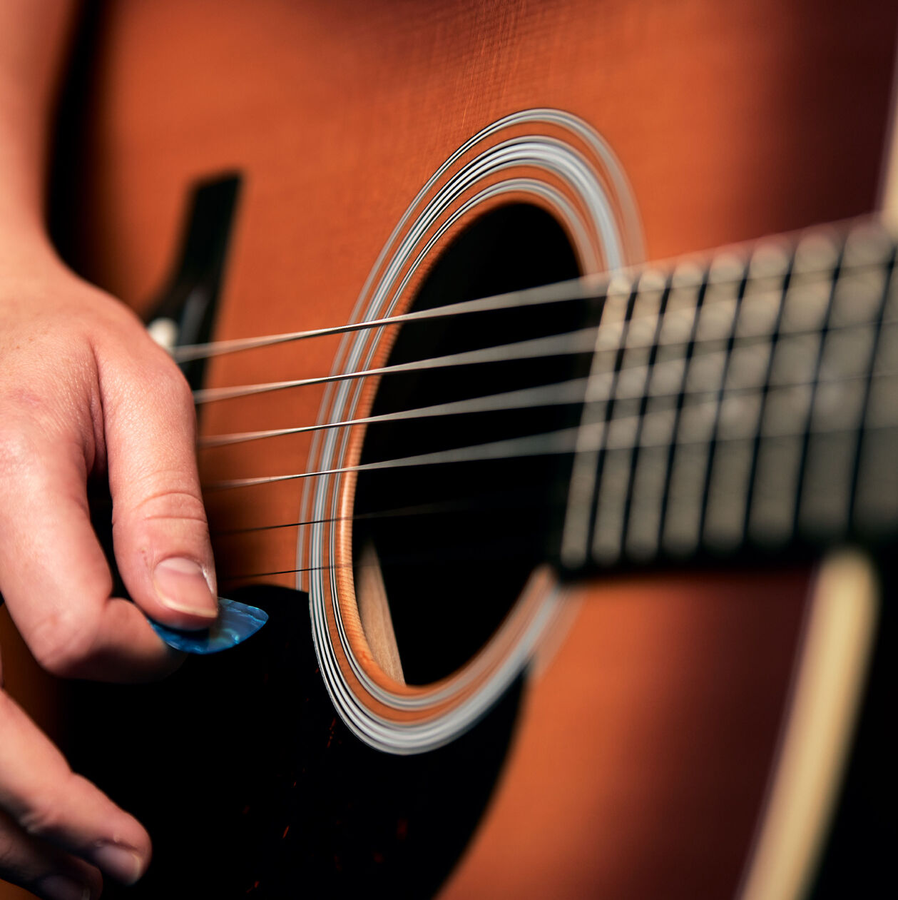 Person strumming a guitar