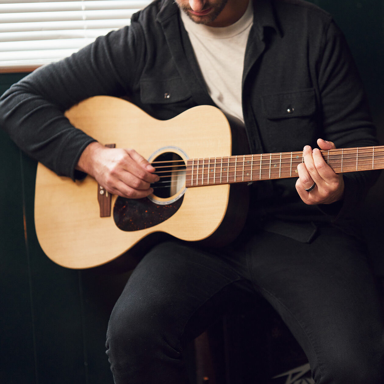 Man seated playing guitar