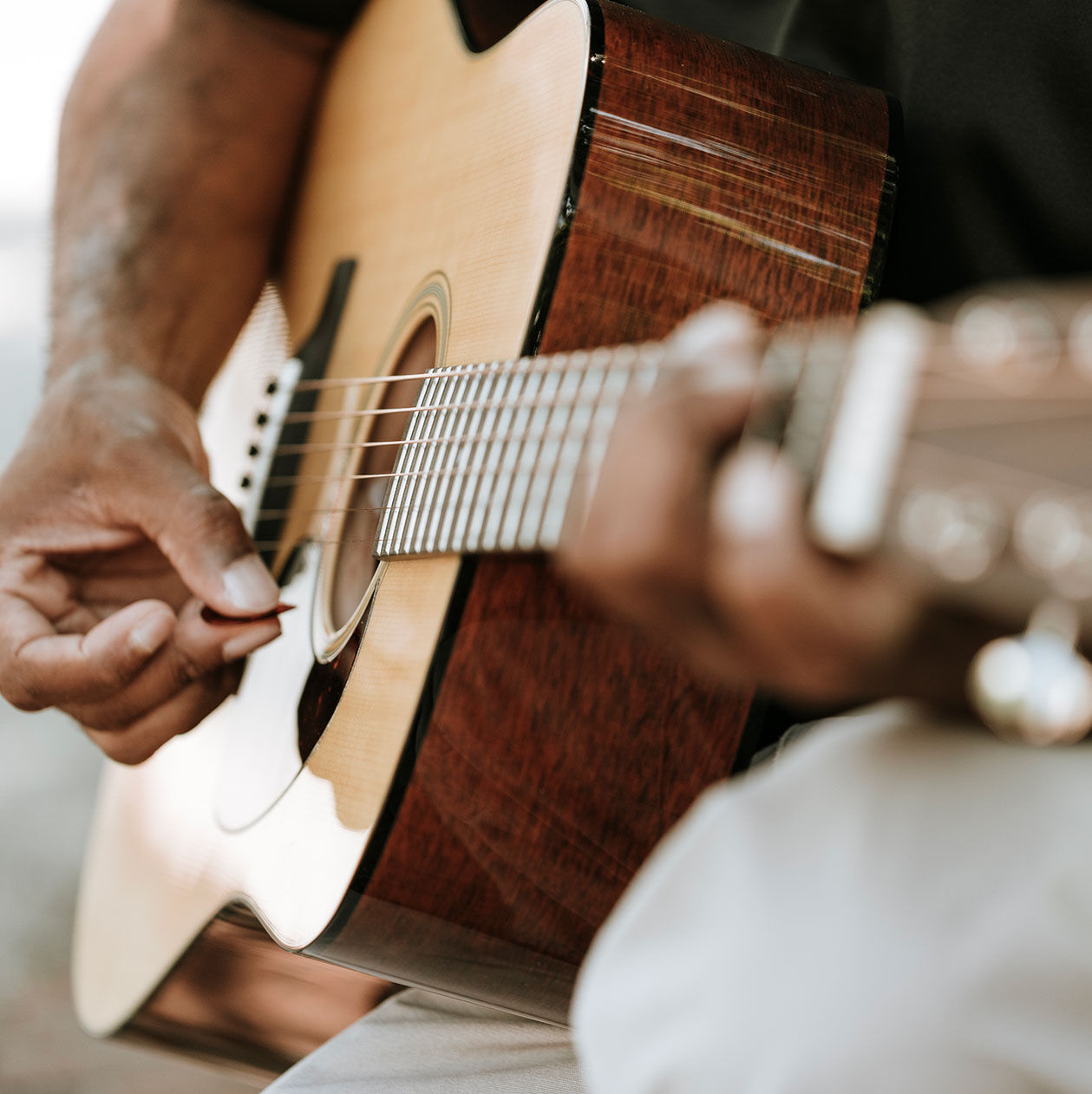 Person playing an acoustic guitar