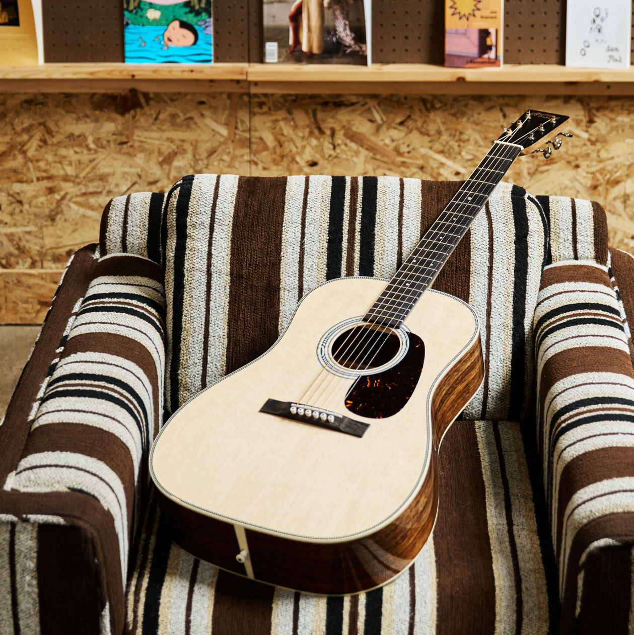 Acoustic guitar laying on a patterned chair
