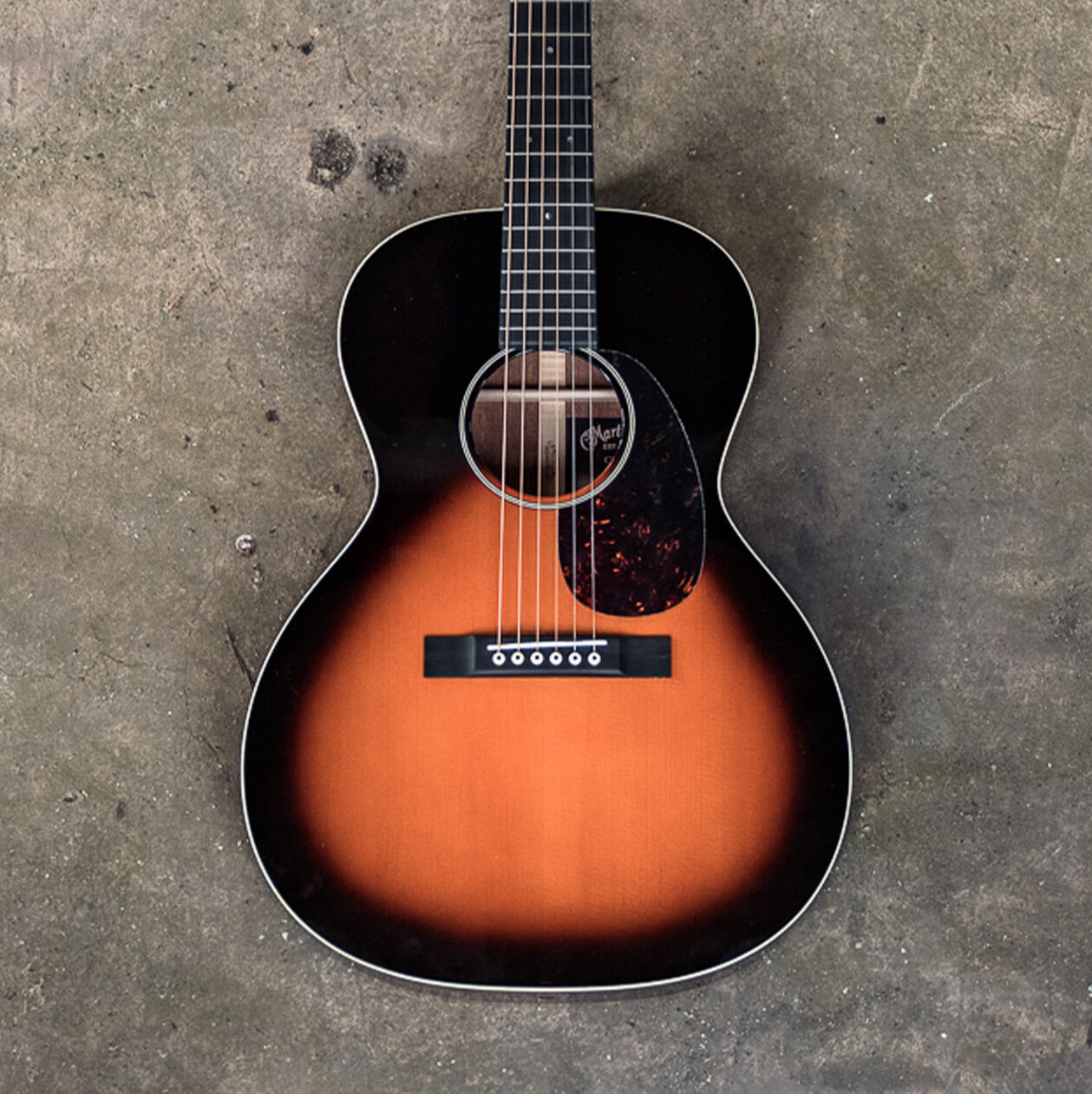 Guitar leaning laying on concrete floor