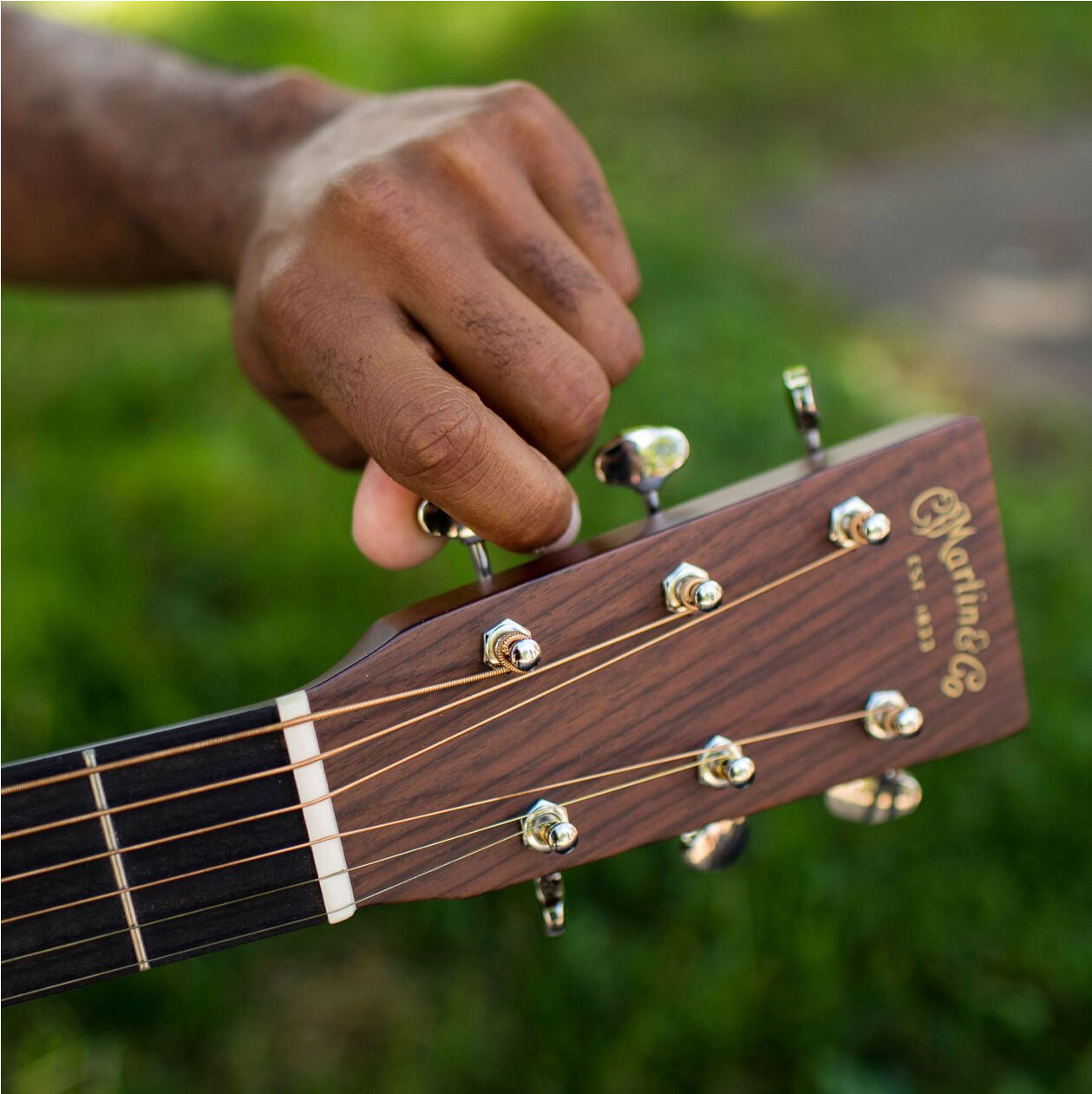 Close up of a hand tuning a guitar