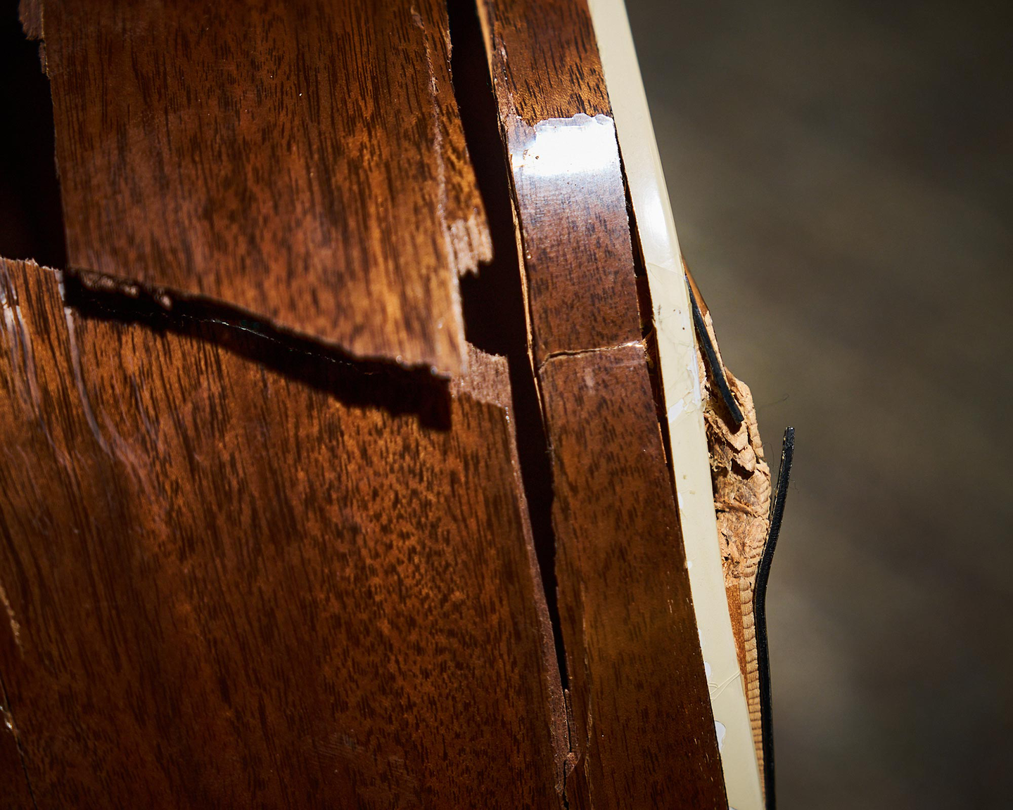 A large crack in the sidewall of an acoustic guitar