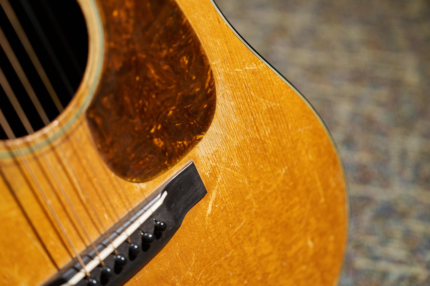 A photo of James Taylor's 1937 D-18, showing the bridge, pickguard, and lower area of the front