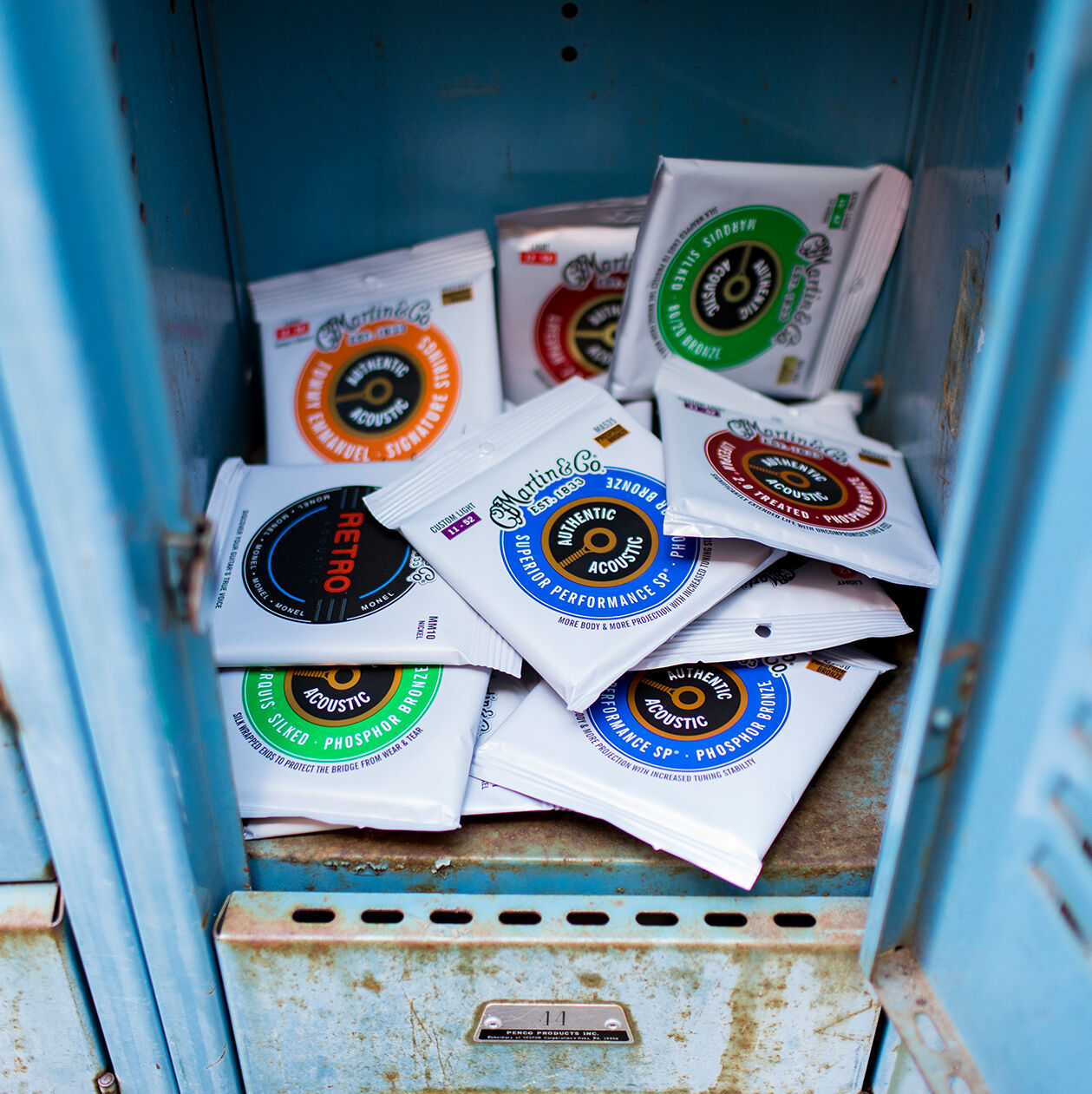 A handful of guitar string packages in a locker