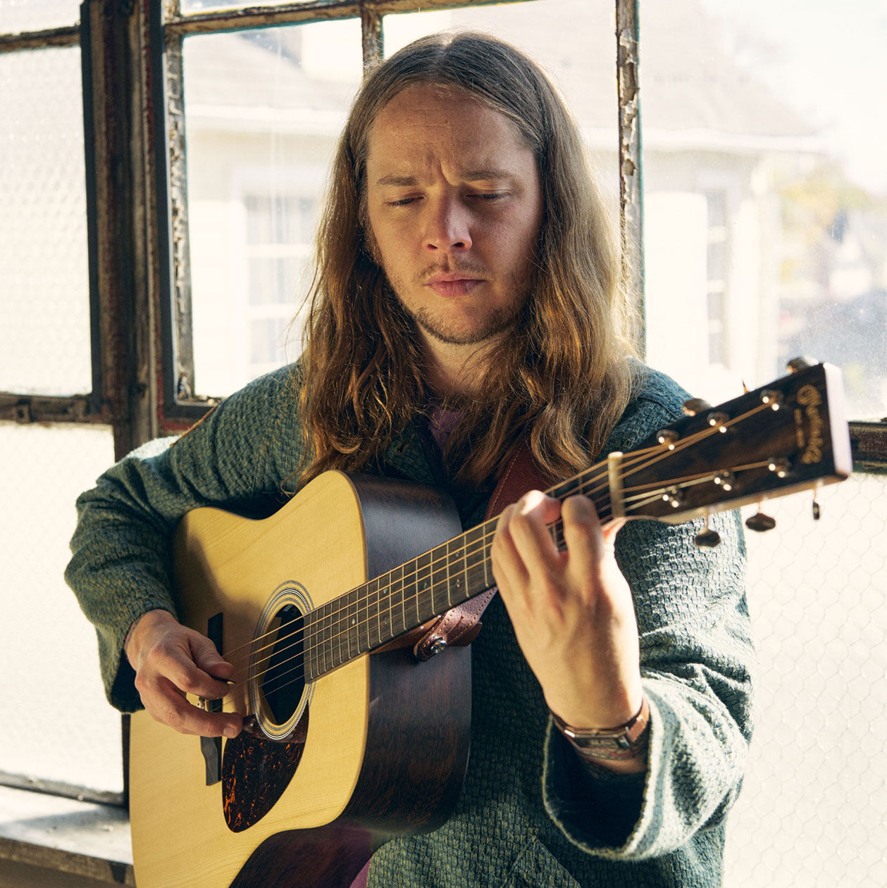 Billy Strings playing an acoustic guitar