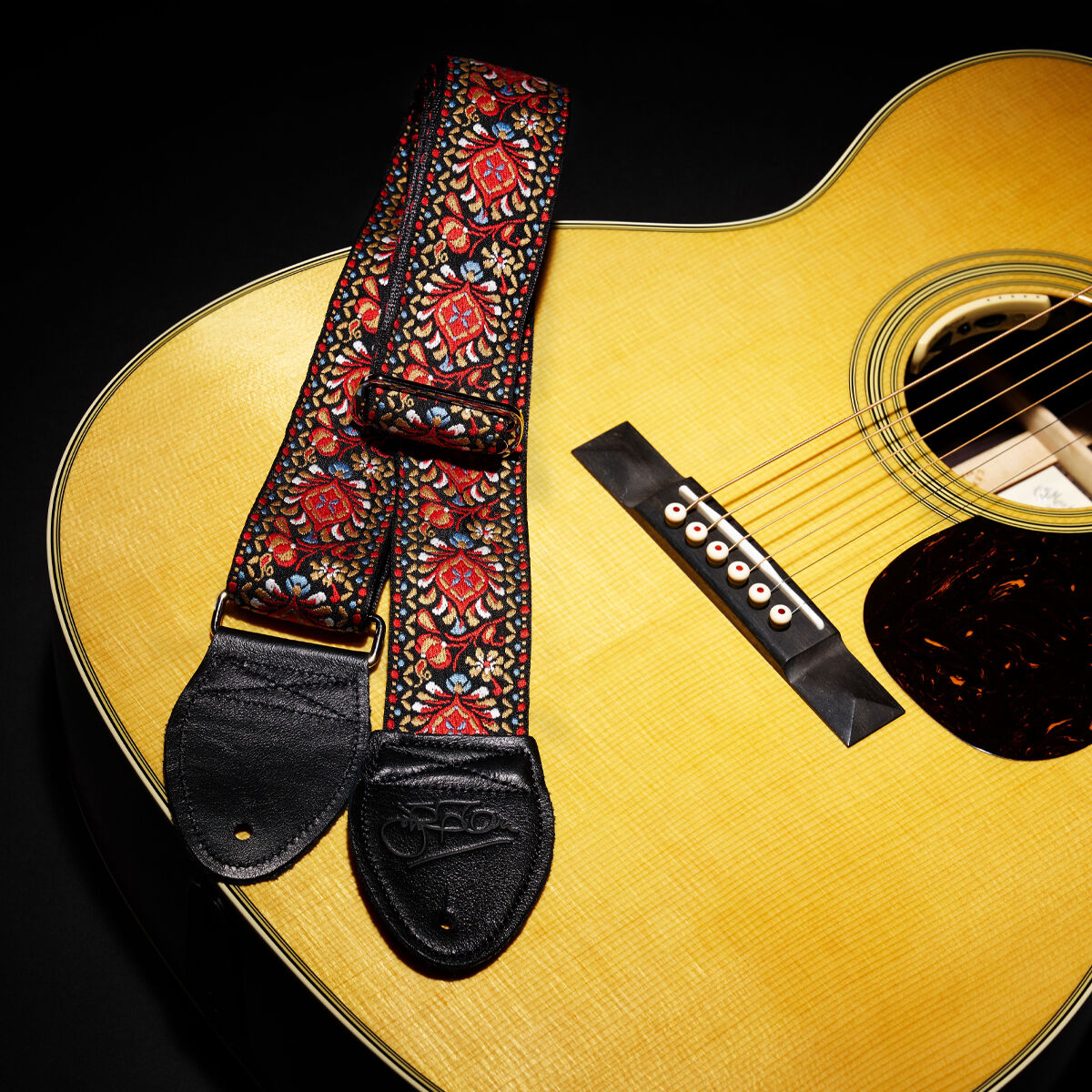 Strap resting on front of acoustic guitar