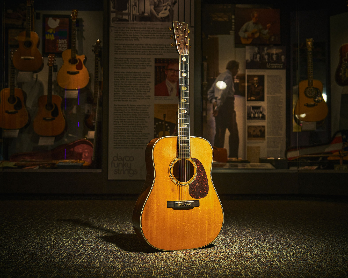 A pre-war D-45 acoustic guitar in dramatic lighting at the Martin Museum