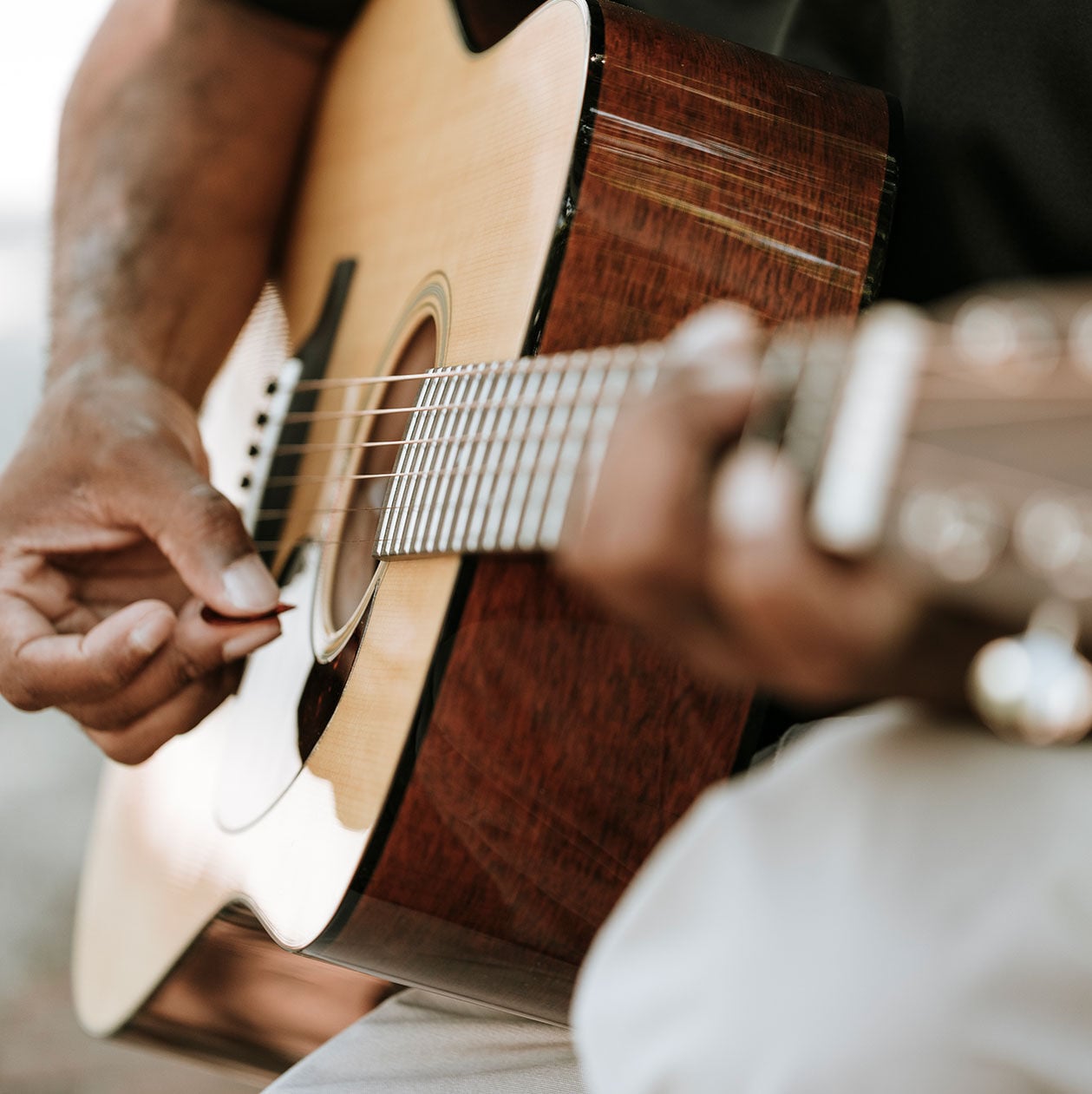 Person playing an acoustic guitar