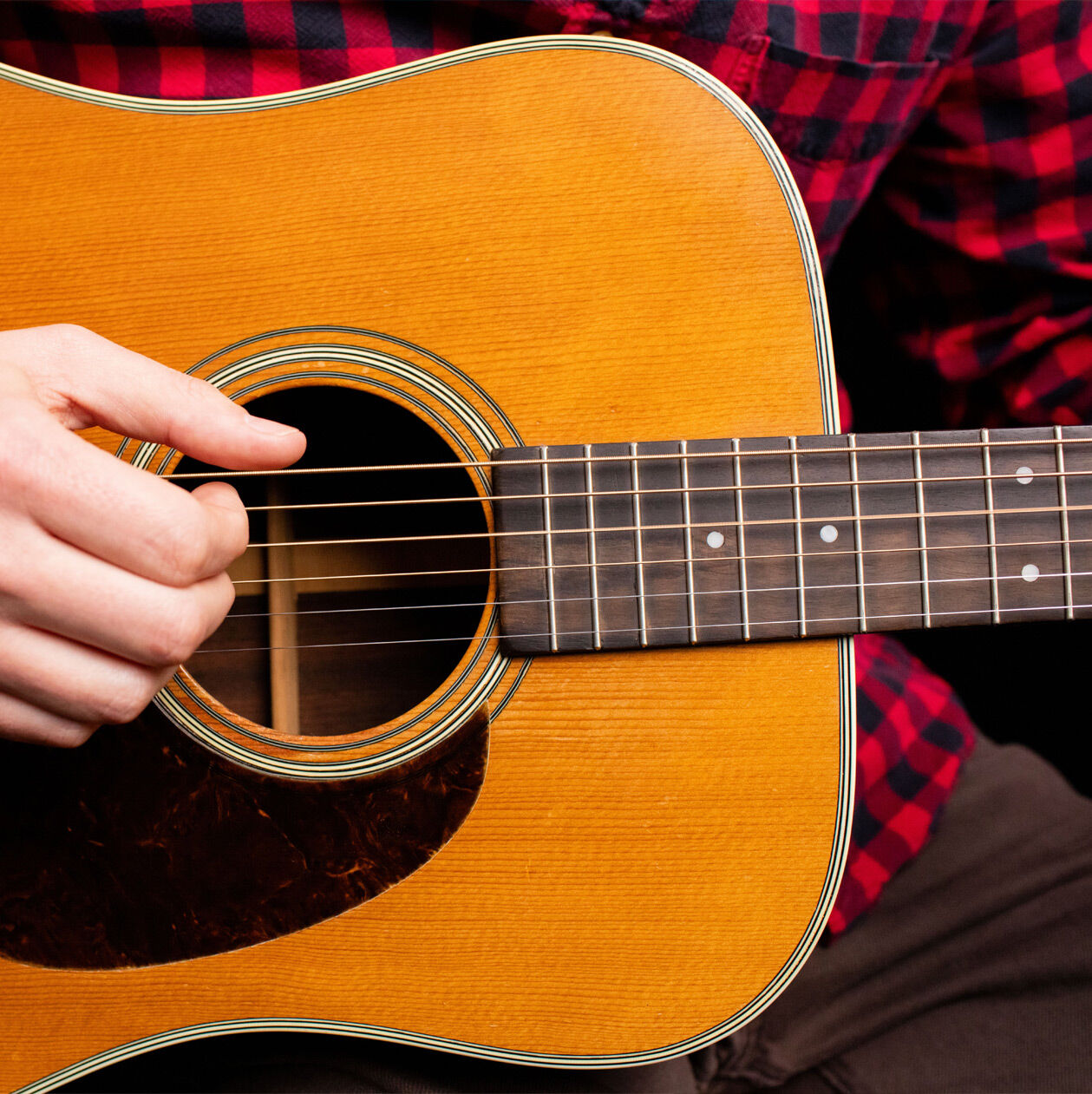 A hand playing finger style guitar